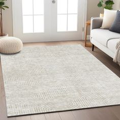 a living room with a white couch and rugs on the hardwood floor next to a door