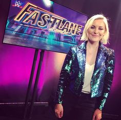 a woman standing in front of a tv screen with the words fastlane on it