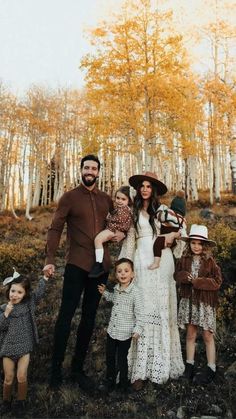 a family posing for a photo in the woods with their two children and one adult