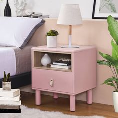 a pink nightstand next to a bed in a room with a white rug on the floor