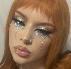 a woman with red hair and silver glitter make - up looks at the camera while posing for a photo