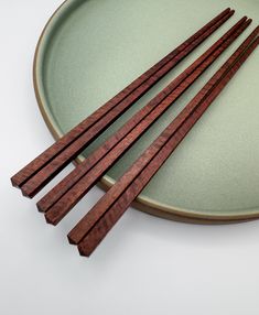 four chopsticks are sitting on a plate