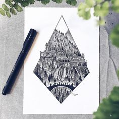 a pen is sitting on top of a piece of paper next to a drawing of a mountain