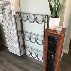 a tall wooden shelf sitting next to a wall with a plant on top of it