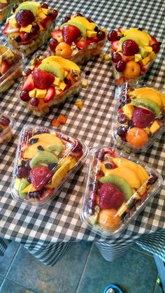 many different types of fruit in plastic containers on a table