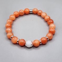 Orange jade bracelet , very beautiful , genuine jade beads nice  vibrant  orange color ( color enhanced) with natural white jade focal bead. This Jade bracelet has 8 mm beads , strong sturdy stretch cord and long lasting silver plated brass spacers.  The bracelet come gift wrapped and if it's a gift I can include a card with your short personal message on it for free.. :) Size: Please make sure you measure your wrist as the picture shows and select the wrist size. ( you DON'T have to add an inch anymore!) If you need help ,or it's a gift and don't know the size, contact me and we will figure it out.. :) Meaning : Jade brings harmony in your life and protects you from harm, accidents and misfortune. Stabilizes your personality, calms the minds, release negative thoughts, keeping things in p Cheap Cute Orange Beaded Bracelets, Orange Agate Gemstone Bracelets, Elegant Orange Bracelet, Elegant Orange Beaded Bracelets With Gemstones, Elegant Orange Gemstone Beaded Bracelets, Orange Gemstone Beaded Bracelets With Round Beads, Orange Gemstone Beaded Bracelets, Orange Agate Gemstone Bead Bracelets, Orange Agate Gemstone Beads Bracelet