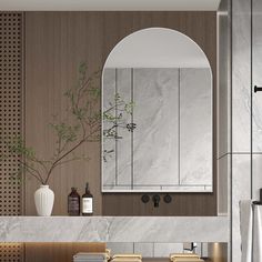 a modern bathroom with marble counter tops and wooden cabinets, along with an arched mirror over the sink