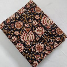 a black and red flowered pattern on a white background with gold trimmings