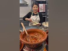 a woman in an apron is cooking some food