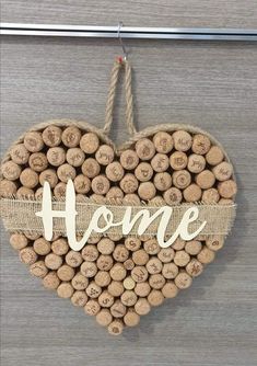 a heart shaped wine cork decoration with the word home written in white letters on it