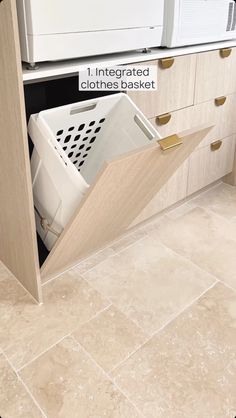 a white washer sitting inside of a kitchen next to a dryer and cabinets