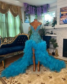 a mannequin in a blue dress sitting on top of a rug next to a couch