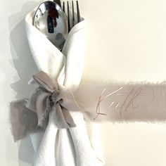 a fork, spoon and napkin wrapped in white cloth with the word let it be