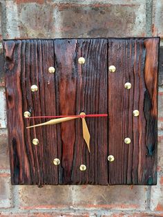 a clock made out of wooden planks on the side of a brick wall