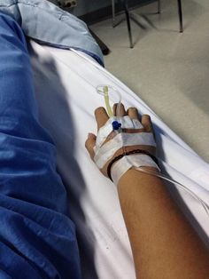 a person in a hospital bed with bandages on their arm and an iv attached to the arm