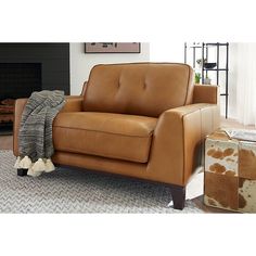 a brown leather couch sitting on top of a rug