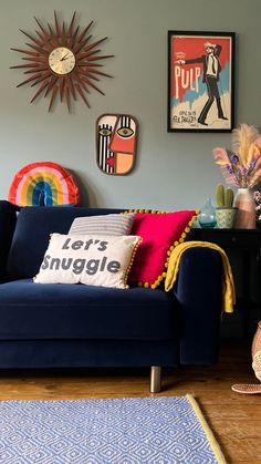 a living room with blue couches and pictures on the wall