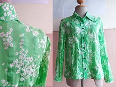 "This cotton blouse is in green cotton cotton with cute floral print. Classic 70s mod shirt collars Darts at chest Vintage Button front entry All original buttons are in place. Long sleeves. Very lightweight. Actual color may be slightly different than shown. CONDITION: very good vintage condition In Measurements(taken flat): Shoulders: 15\" Bust: 18\" Waist : 17\" Total Length: 25\" Sleeve length : 21\" Freshly cleaned and ready to wear To see more items, visit : www.RetroTheory.etsy.com" Green Floral Print Button-up Shirt, Green Tops With Vintage Print, Green Collared Shirt For Spring, Green Vintage Print Blouse For Spring, Green Vintage Print Top For Spring, Retro Green Shirt For Spring, Spring Green Blouse With Vintage Print, Green Collared Top With Floral Print, Retro Green Printed Blouse