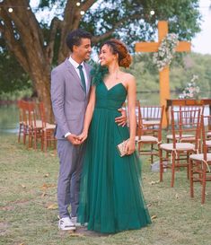 a man and woman standing next to each other in front of an outdoor ceremony area