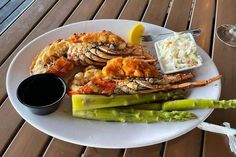 a white plate topped with shrimp and asparagus