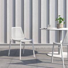 two chairs and a table in front of a wall with vertical blinds