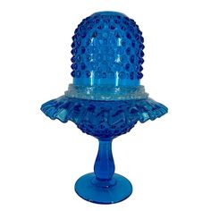 a blue glass cake dish on a stand with holes in the top and bottom part