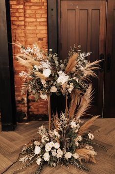 an arrangement of flowers and feathers on a wooden floor