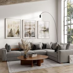 a living room with two couches, a coffee table and three pictures on the wall