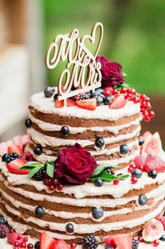 a multi layer cake with berries and strawberries on top