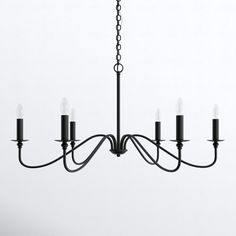 a black chandelier with five candles hanging from it