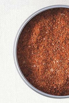 a metal bowl filled with red spices on top of a white cloth