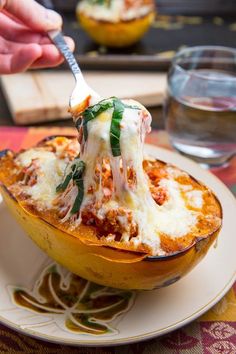 a person is eating spaghetti in a squash dish on a plate with a knife and fork