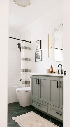 a bathroom with gray cabinets and white walls