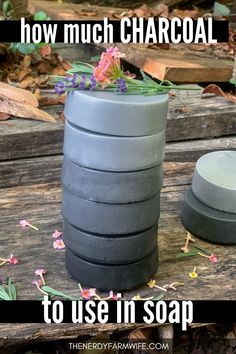 a stack of soaps sitting on top of a wooden table with flowers growing out of them