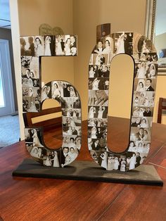 the number 50 is made out of photos and sits on a table in front of a mirror