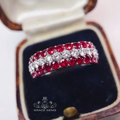 a red and white diamond ring in a box