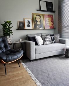 a living room filled with furniture and pictures on the wall next to a large window