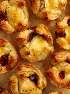 many small pastries are arranged together on a sheet of wax paper with cranberry sauce in the middle