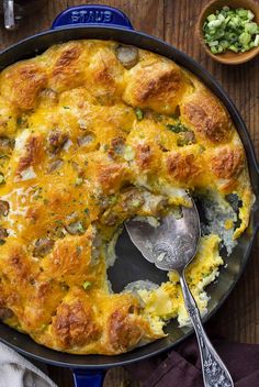 a casserole with meat and cheese in a blue dish on a wooden table