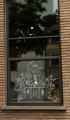 a window with a drawing on it in front of a brick building