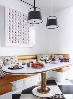 a table with some food on it and two lamps hanging over it in front of a window