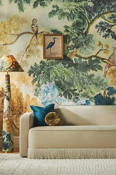 a living room scene with focus on the couch and wallpapered walls behind it