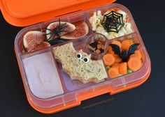 an orange lunch box filled with halloween food