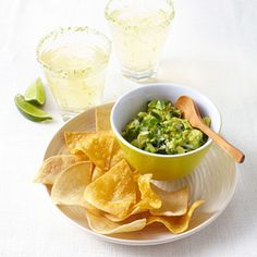 a bowl of guacamole and tortilla chips on a plate