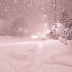 a snow covered street at night with traffic lights