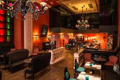 the interior of a restaurant with chandeliers hanging from the ceiling and colorful lights on the walls