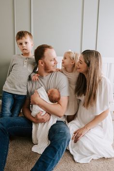 a family sitting on the floor with their baby