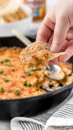 a person dipping some food into a skillet