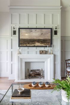 a living room filled with furniture and a fire place in front of a painting on the wall