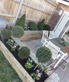 an outdoor patio area with potted plants and wooden planters on the side of it